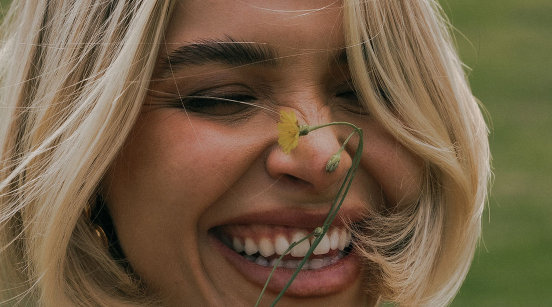 Blonde woman with flower near her face