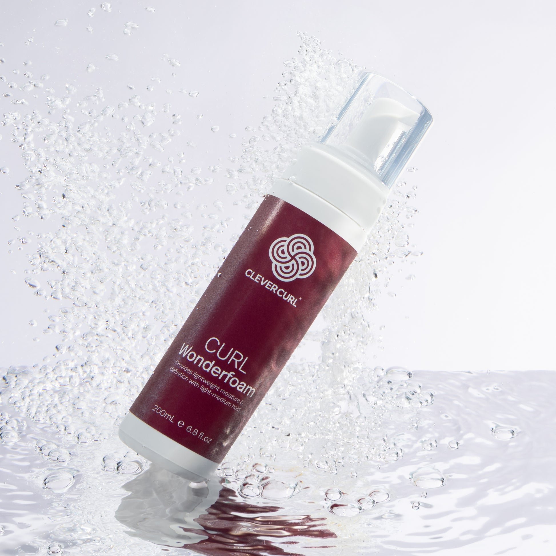 Clever Curl Curl Wonderfoam 200ml bottle with water droplets on a light gray background