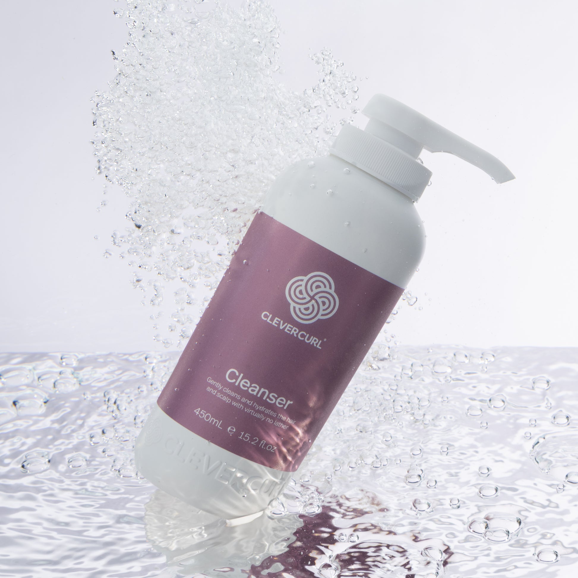 Clever Curl Cleanser 450ml bottle with pump on a textured white background