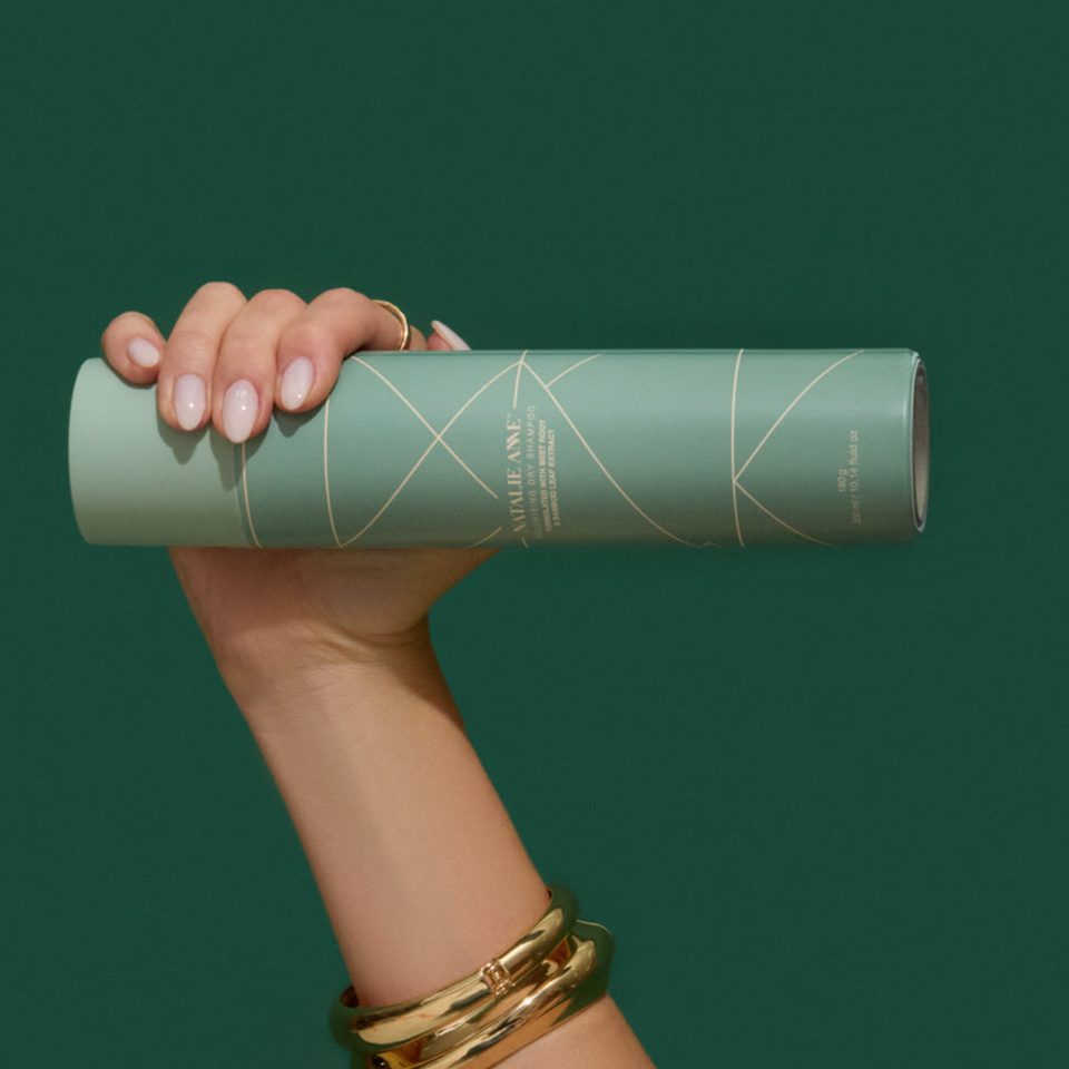 Natalie Anne Volumising Dry Shampoo held in hand with green background